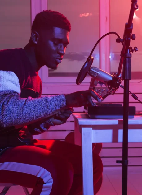 African american professional musician recording synthesizer in digital studio at home, music production technology concept. African american professional musician recording guitar in digital studio at home, music production technology concept